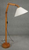 A floor standing full height reading lamp on an articulated adjustable column. H.160cm