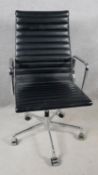 An Eames inspired desk chair in ribbed black leather upholstery on chrome frame and base. H.110 W.