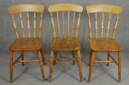 Three 19th century elm seated stick back kitchen chairs. H.84cm