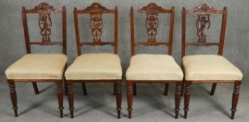 A set of four 19th century oak dining chairs with floral carved splats. H.90cm (one splat damaged as