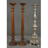 A pair of turned candlestands and a metal ecclesiastic style pricket candlestick. H.64cm
