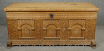 A late 19th century Continental carved light oak coffer with twin carrying handles on shaped