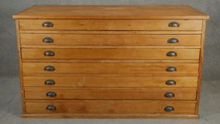A vintage pine architect's plan chest of seven drawers with brass cup handles. H.94 W.155 D.77cm