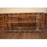 An X framed teak console table with three plate glass tiers. H.72 W.140 D.33cm