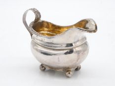 A Georgian sterling silver gravy boat with gilded interior. Rope design to the edges and repousse