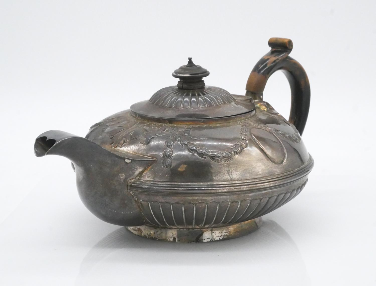 A sterling silver Georgian teapot with dragooned detailing and repousse swag and bow motifs. - Image 2 of 7