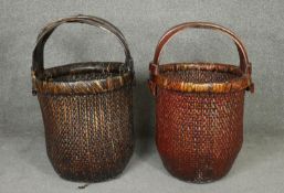 A pair of woven straw Chinese rice baskets with carrying handles. H.65cm
