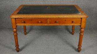 A 19th century mahogany writing table with two frieze drawers raised on turned tapering supports.