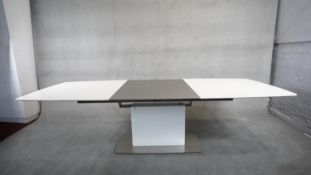 A contemporay Bo Concept extending dining room table with integral folding central leaf on