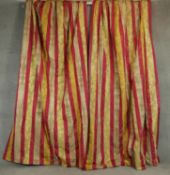 A pair of silk mix red, gold and cream striped lined curtains with a stylised floral and foliate