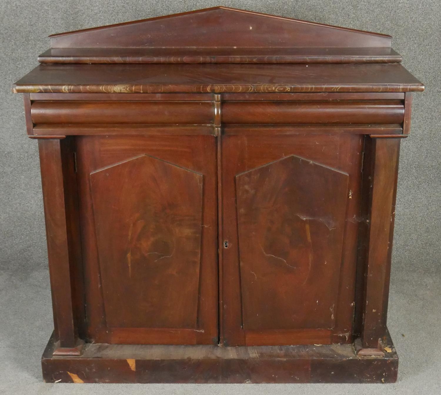 A mid 19th century flame mahogany chiffonier with raised back above frieze drawers and arched