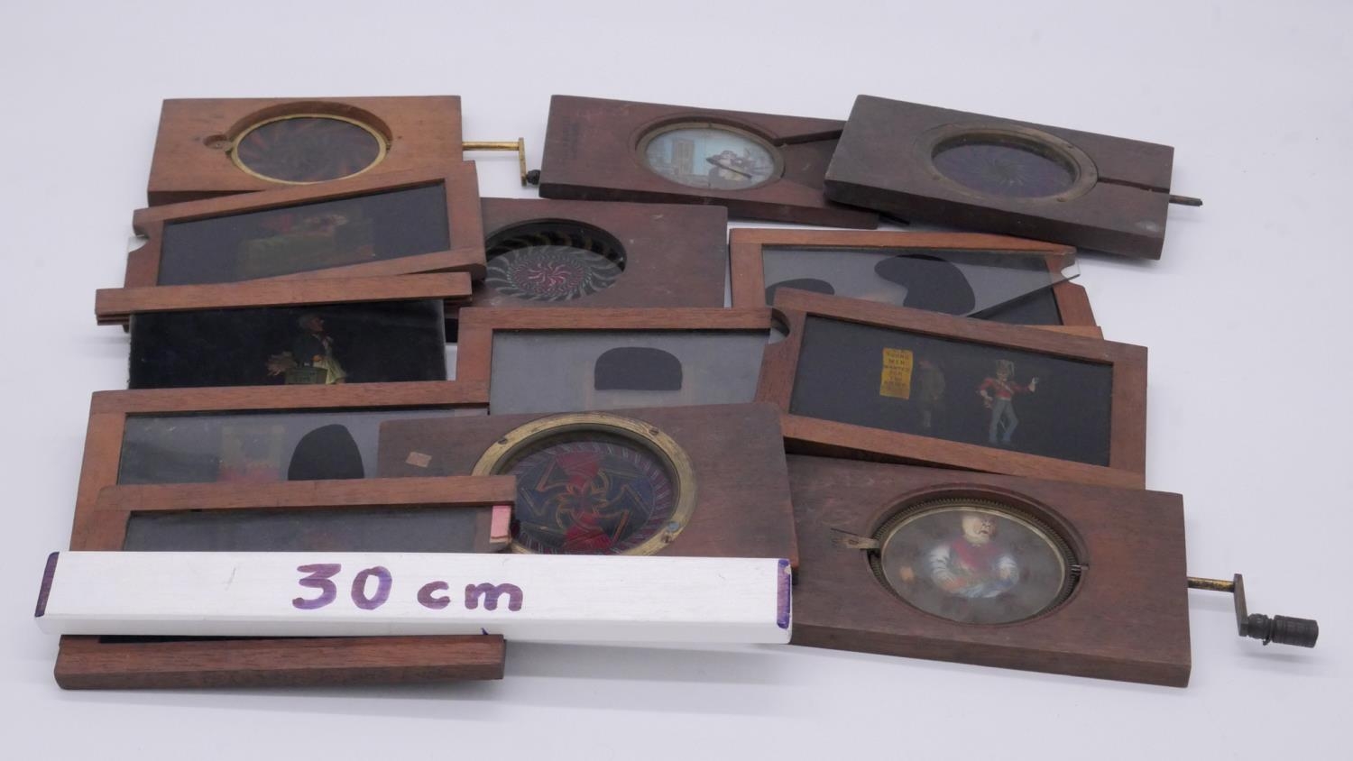 Thirteen mechanical 19th century wooden coloured glass magic lantern slides. Various designs and - Image 5 of 5