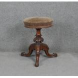 A Victorian carved walnut revolving adjustable piano stool on tripod cabriole base. h50 d45