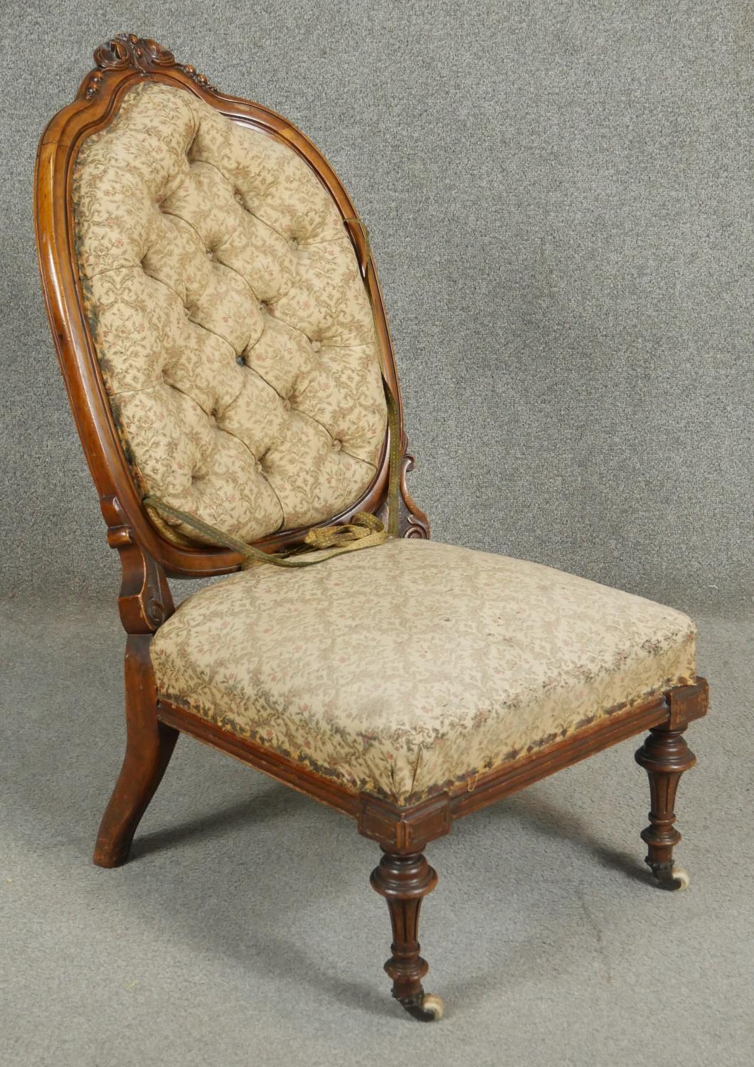 A Victorian walnut nursing chair with floral carved back rail and buttoned upholstery on tapering - Image 2 of 5