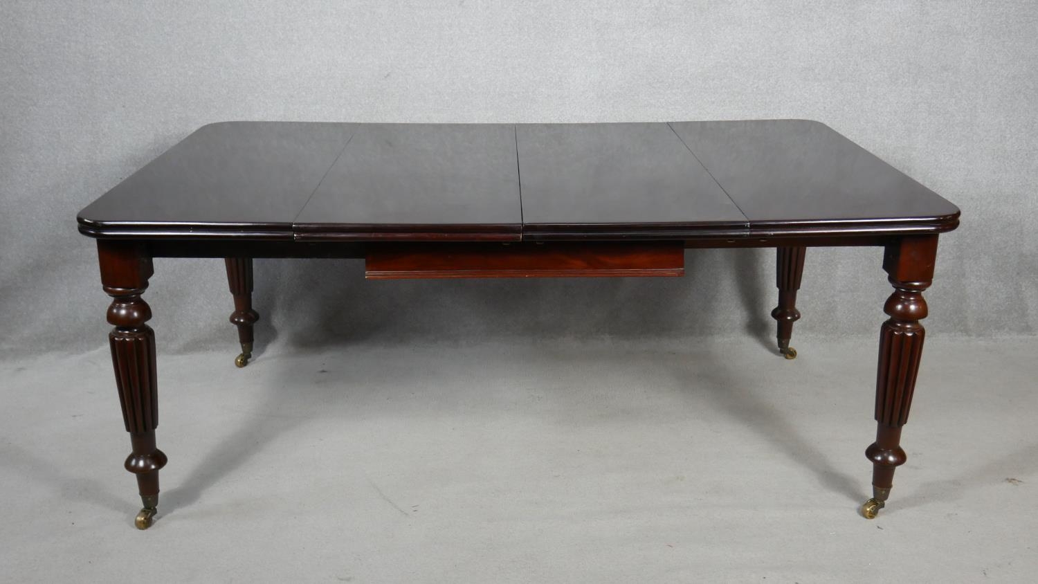 A William IV style mahogany extending dining table with two extra leaves on reeded tapering supports - Image 2 of 5