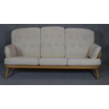 A vintage light beech framed Ercol style sofa with fitted upholstery. L190cm