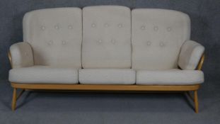 A vintage light beech framed Ercol style sofa with fitted upholstery. L190cm