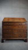 A Georgian flame mahogany and crossbanded bureau with fitted interior on shaped bracket feet. H.