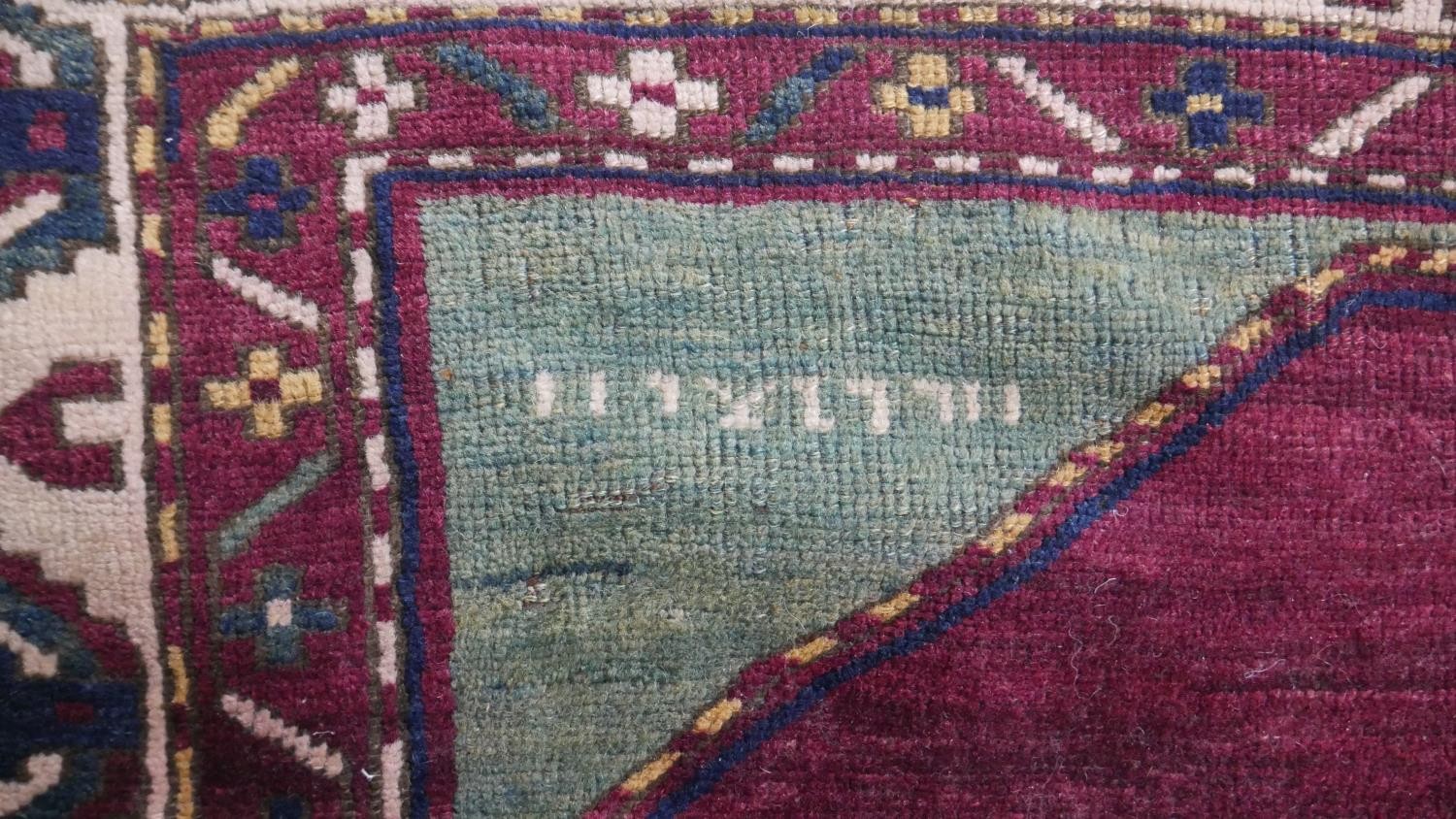 A Kazak rug with central lozenge medallion on burgundy field within jade spandrels (one signed) - Image 5 of 5