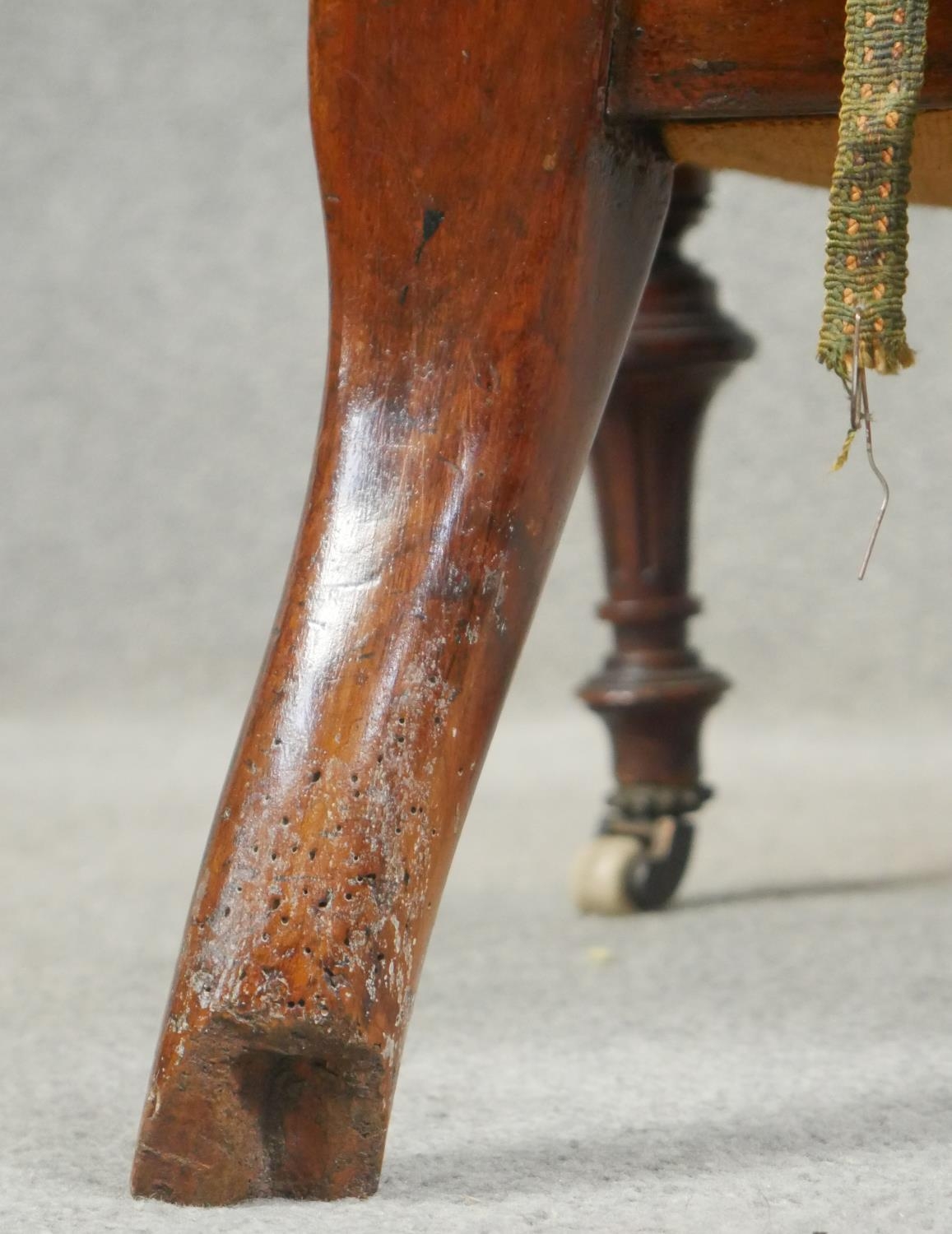 A Victorian walnut nursing chair with floral carved back rail and buttoned upholstery on tapering - Image 5 of 5