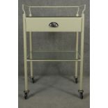 A vintage medical style trolley with back rail and glass top and undertier on casters. H.98 W.62 D.