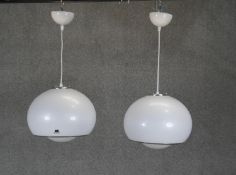 A pair of vintage Guzzini pendant light fittings with maker's labels.