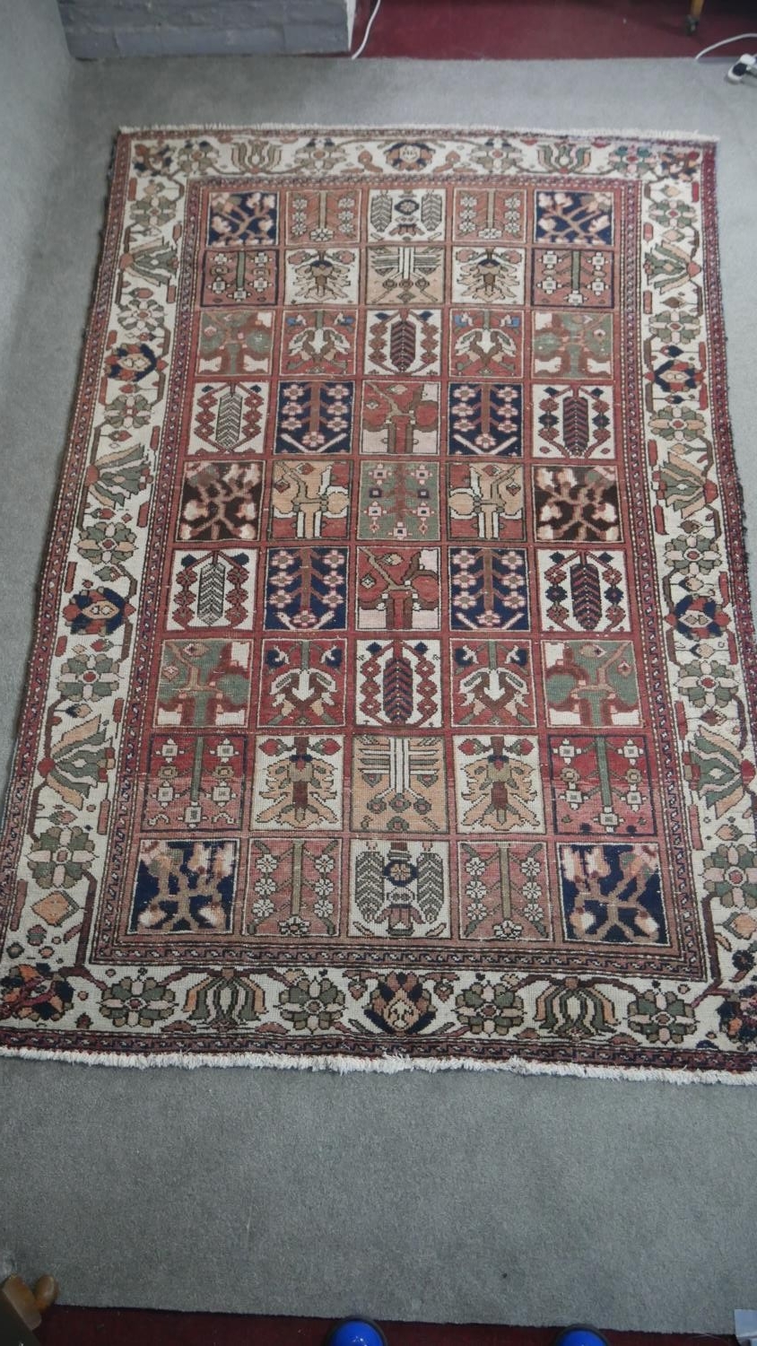 A Baktiar carpet with garden design within palmette and flowerhead borders. L.305 W.196cm