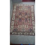 A Baktiar carpet with garden design within palmette and flowerhead borders. L.305 W.196cm