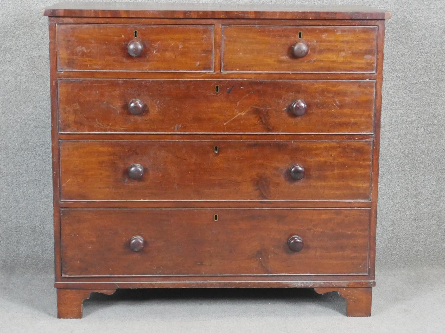 A 19th century mahogany chest with turned knob handles on shaped bracket feet. H97 W103 D50