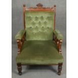 A 19th century carved armchair in buttoned upholstery. H.96cm