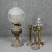 Four antique brass oil lamps one with an etched globe shade. H.54cm