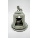 A celadon glaze ceramic tea light holder with foo dog finial. H.17cm
