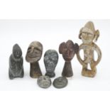 A collection of seven carved hardstone tribal figures, two of faces with hanging loops. H.16cm