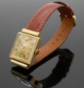 A 14 carat yellow gold vintage mens watch with gold colured dial and black numerals on a brown