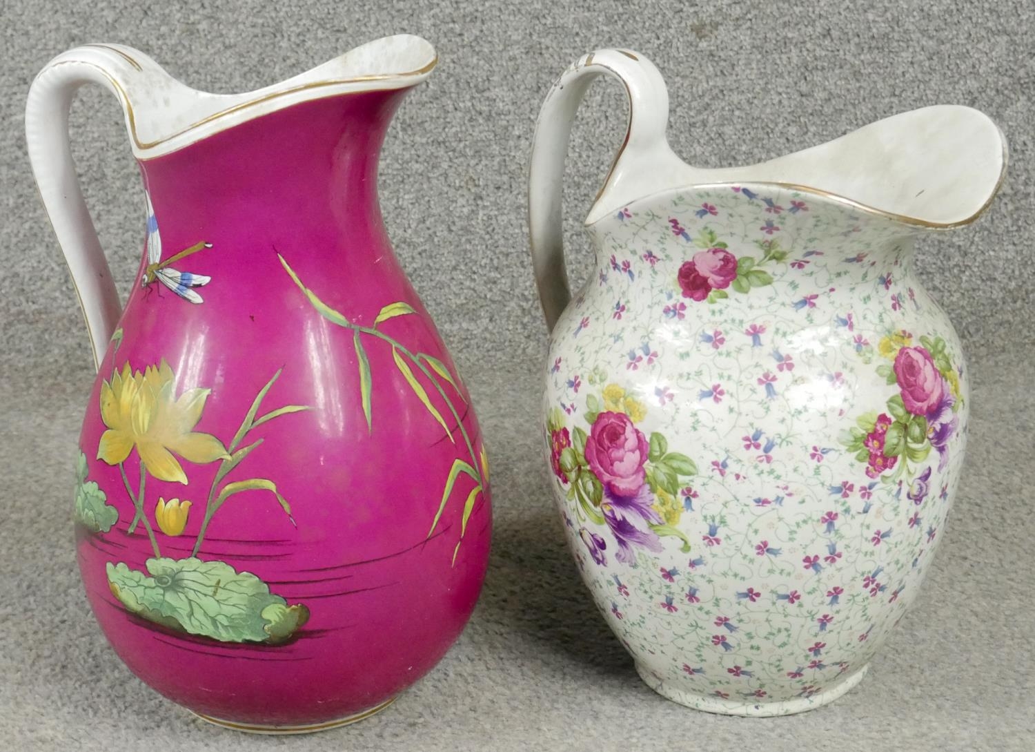 Two Victorian ceramic wash jugs. One with a fuscia ground and decorated with waterlillys and