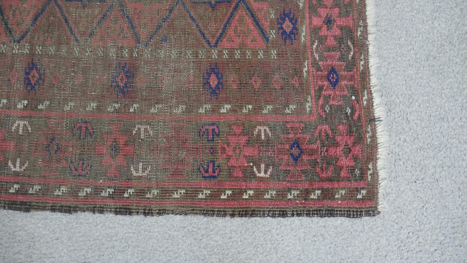A Persian Belouch rug with repeating diamond design on a madder field within multiple borders. L.157 - Image 3 of 4