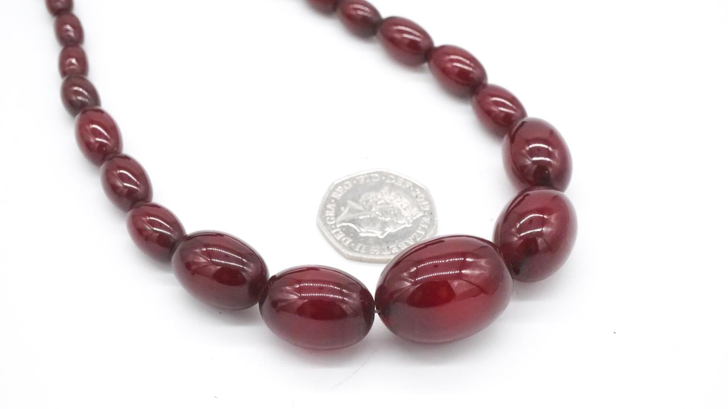 A vintage 30 inch cherry amber bakelite graduated necklace with silver lobster clasp, stamped 925. - Image 4 of 4