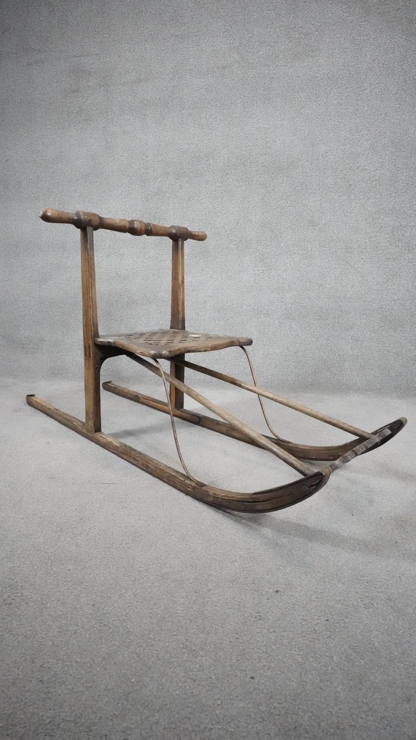 A vintage teak sled with slatted seat on metal faced runners. H.68 L.152cm - Image 2 of 4