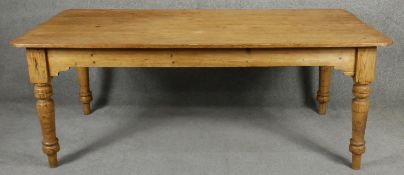 A 19th century pitch pine planked top farmhouse refectory style dining table on turned tapering