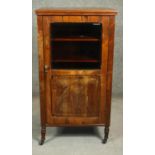 A late 19th century rosewood music cabinet with carved and glazed panel door enclosing sheet music