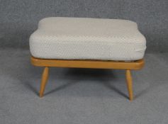 A vintage light beech Ercol style footstool with fitted cushion. L72 W52 H38cm (Damage to webbing as