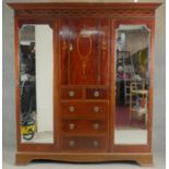 A C.1900 mahogany triple section compactum wardrobe with satinwood scrolling foliate, ribbon and