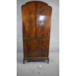 A mid century burr walnut Queen Anne style linen cabinet with panel doors enclosing shelves above