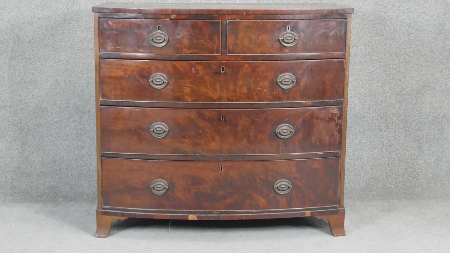 A Georgian flame mahogany bowfronted chest on swept bracket supports. H98 W107 D54cm