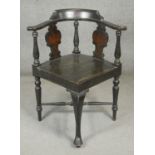 An ebonised corner armchair with Arts and Crafts style pokerwork daffodil decoration to the back