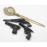 Three Mam Uniwerk, Italy, miniature toy replica cast metal guns and a brass Victorian letter opener.