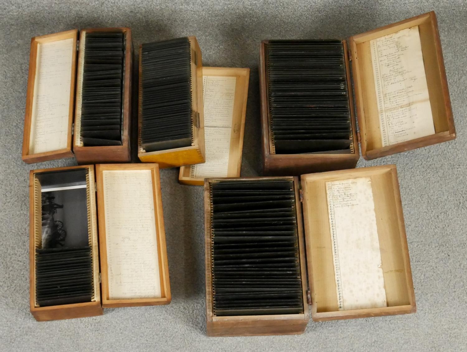 Five wooden boxes of Victorian glass projector slides. Each box with a hand written description of