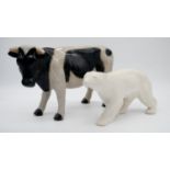 A glazed ceramic cow along with a resin sculpture of a polar bear. H.23cm