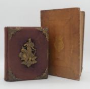 A Victorian red cloth bound photo album with repousse brass detailing along with a leather bound