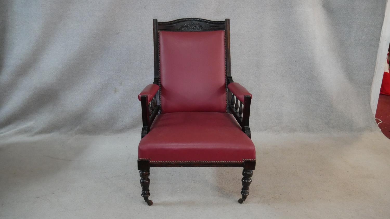 A Victorian carved frame armchair in faux leather upholstery on turned tapering supports. H.98cm